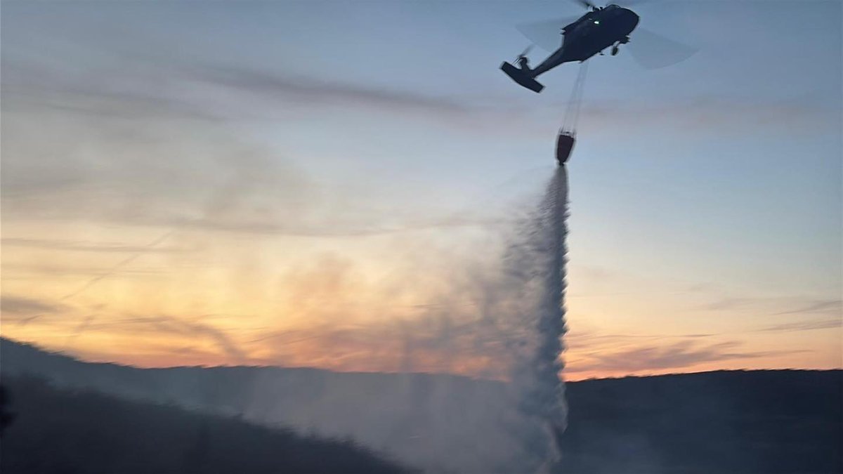 Vrtuľník Black Hawk UH-60 zhadzuje vodu na ohnisko. Mnohé ohniská boli v teréne, kam sa pozemná technika nedostala.